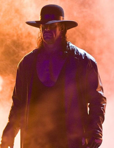 Wrestler The Undertaker in iconic open crown hat and leather duster